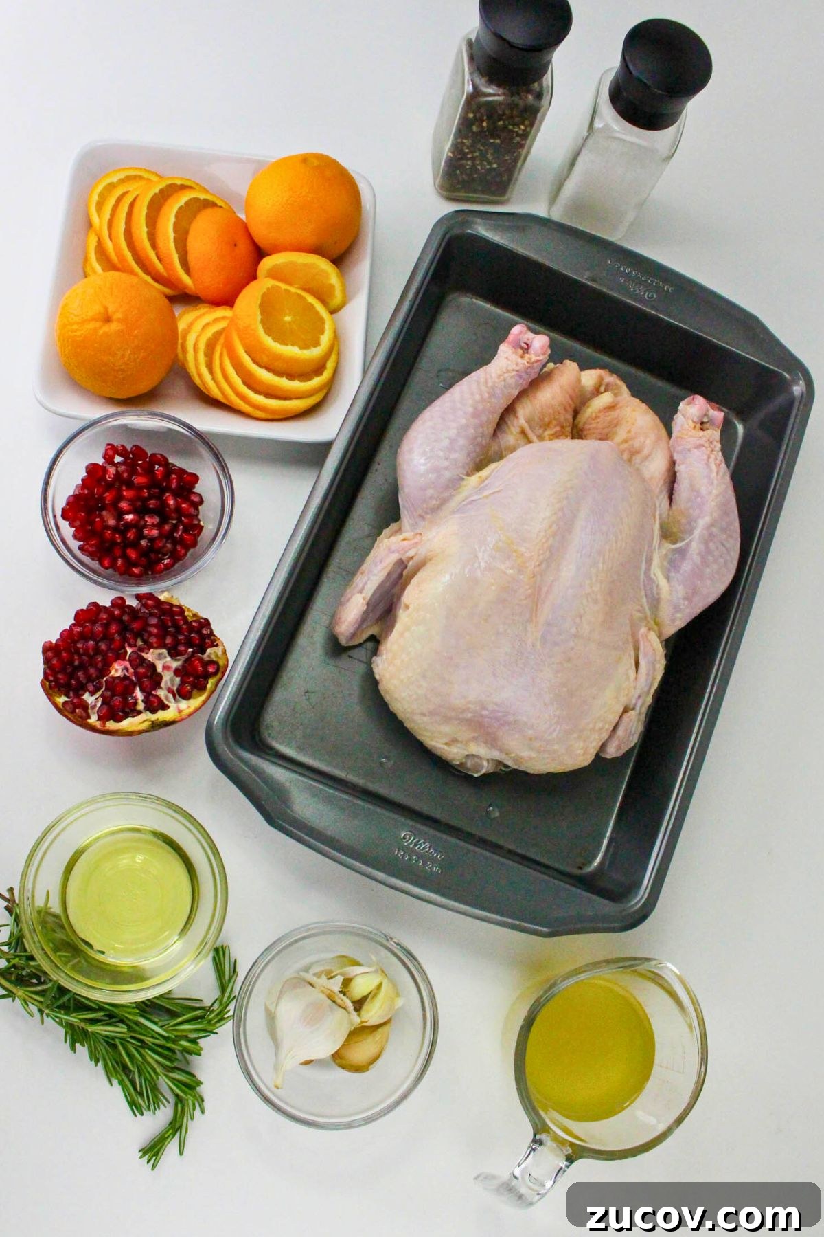Succulent Roast Chicken Recipe for Christmas Dinner 3 An uncooked whole chicken with other ingredients measured out on a marble table.