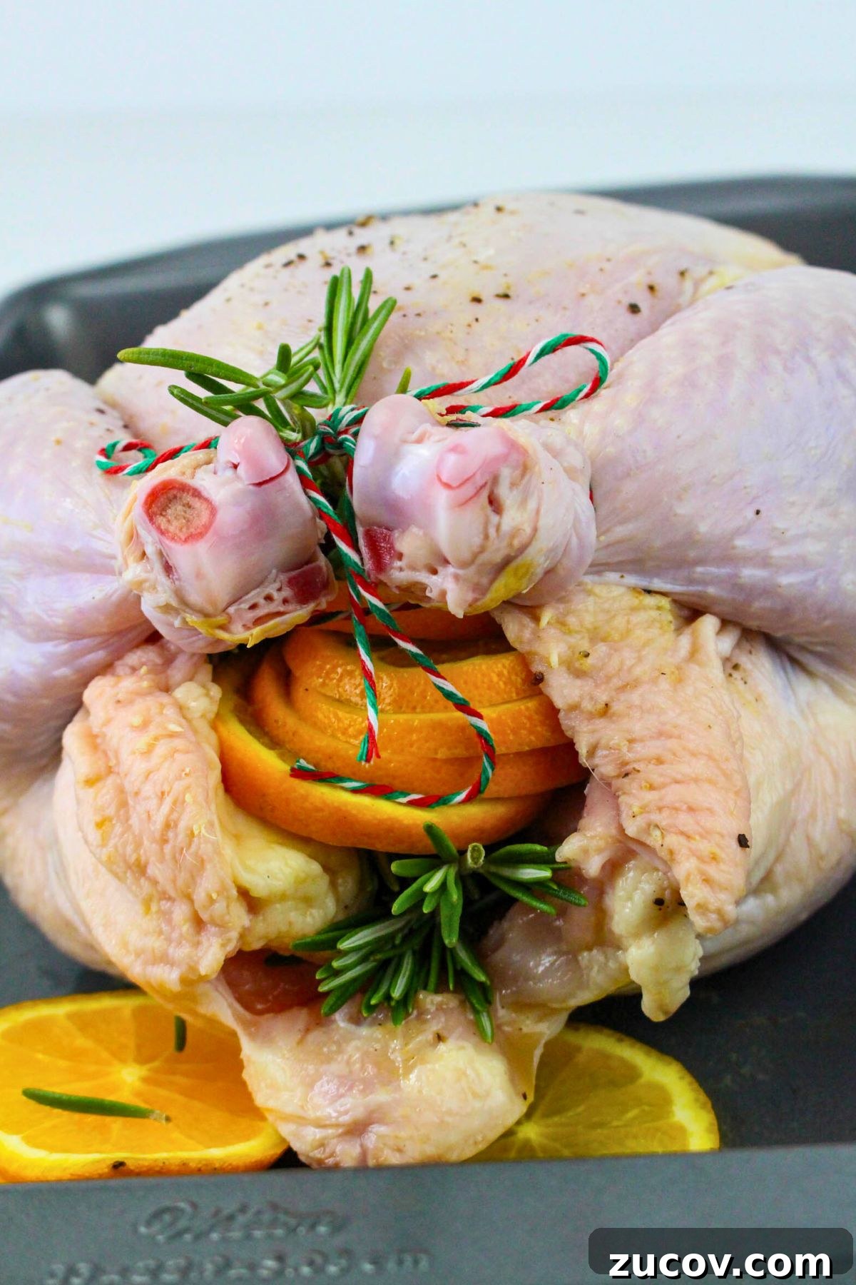 Succulent Roast Chicken Recipe for Christmas Dinner 5 Uncooked chicken stuffed with orange slices and seasonings, then trussed.