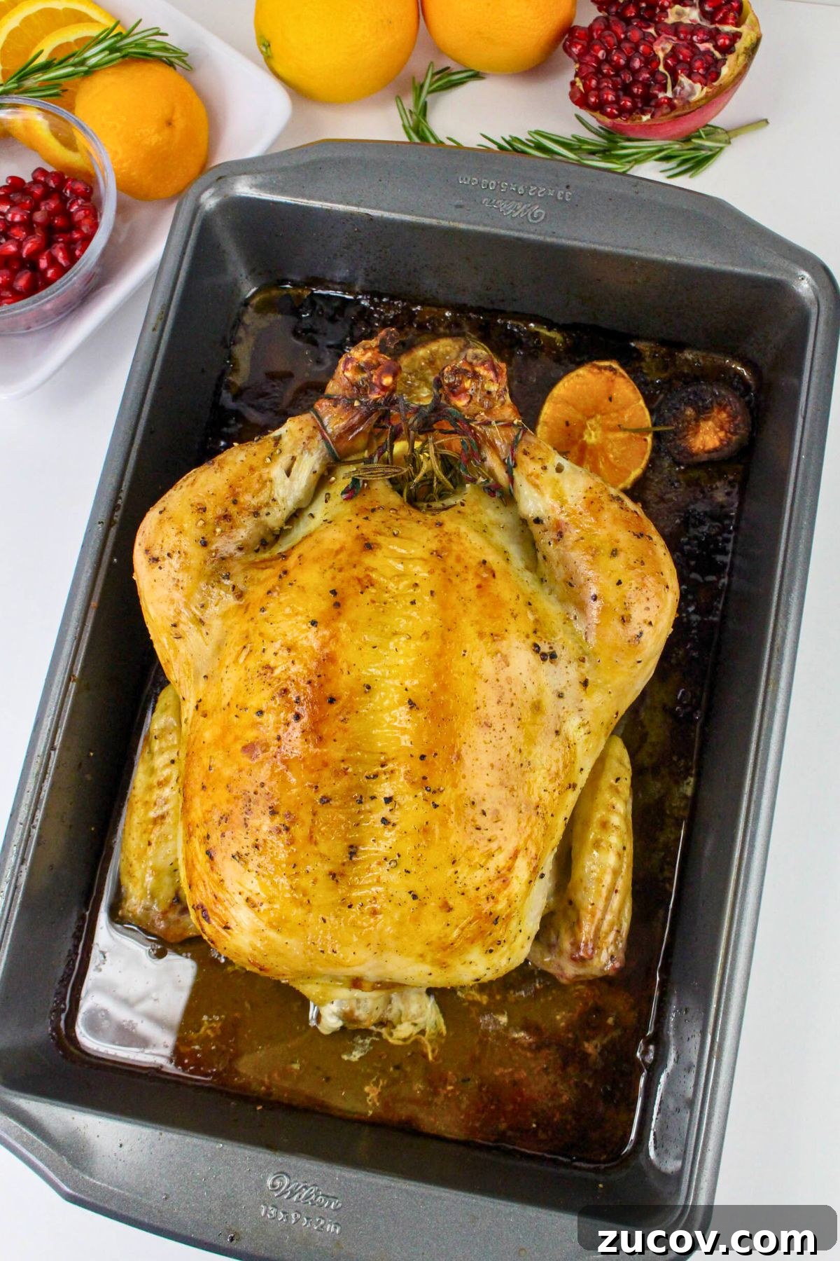Succulent Roast Chicken Recipe for Christmas Dinner 7 Golden roasted chicken in a roasting pan with it's juices at the bottom.