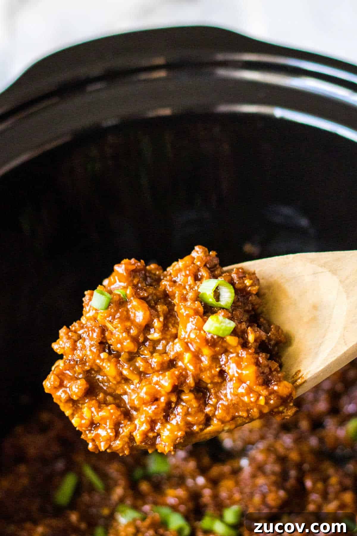 Korean-Style Sloppy Joes in the Slow Cooker: Tangy Gochujang Sandwiches 5 Korean sloppy joe meat on a wooden serving spoon.