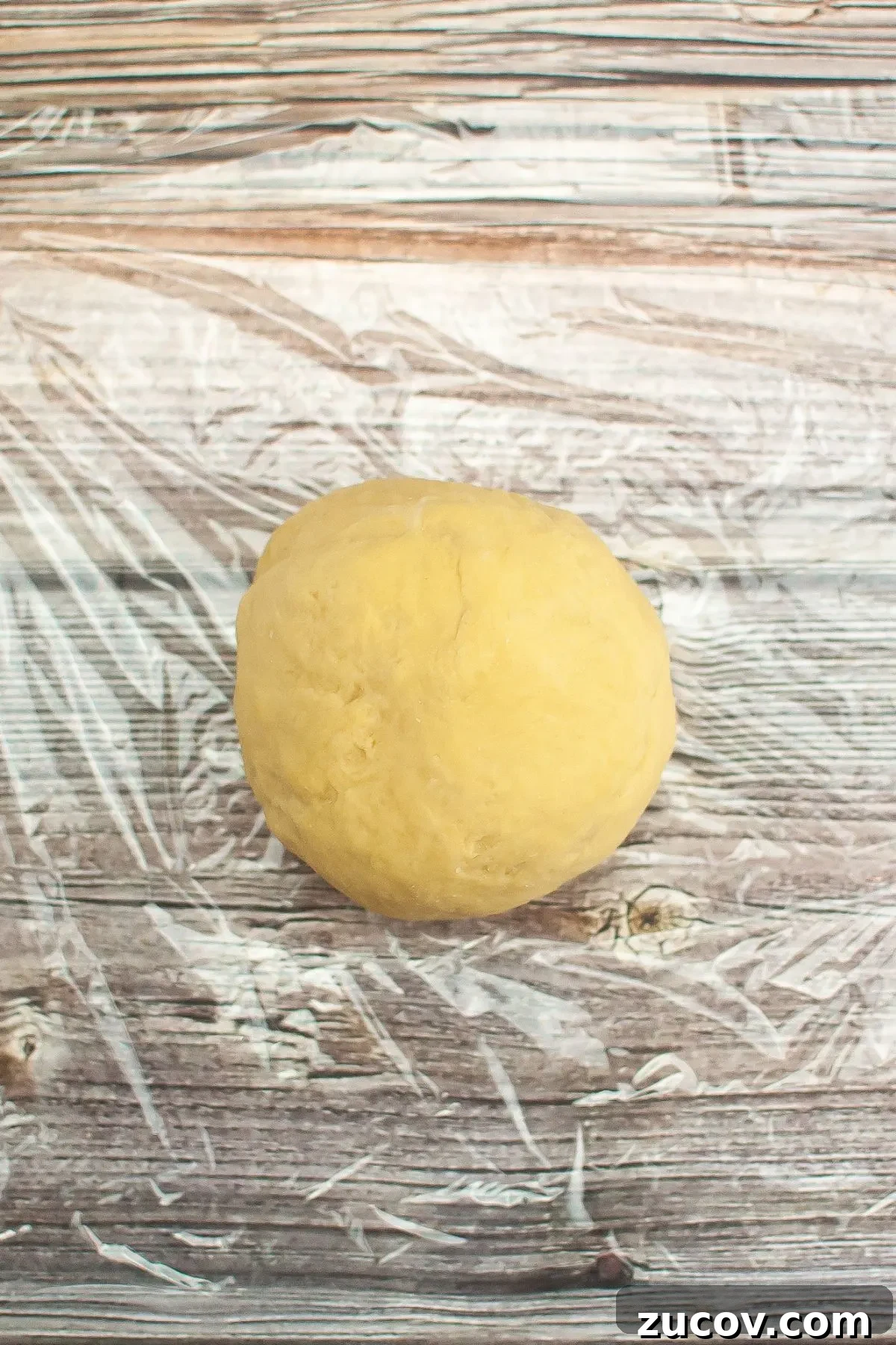 Homemade Gluten-Free Fettuccine Recipe for Perfect Pasta 5 A ball of pasta dough sitting on plastic wrap.