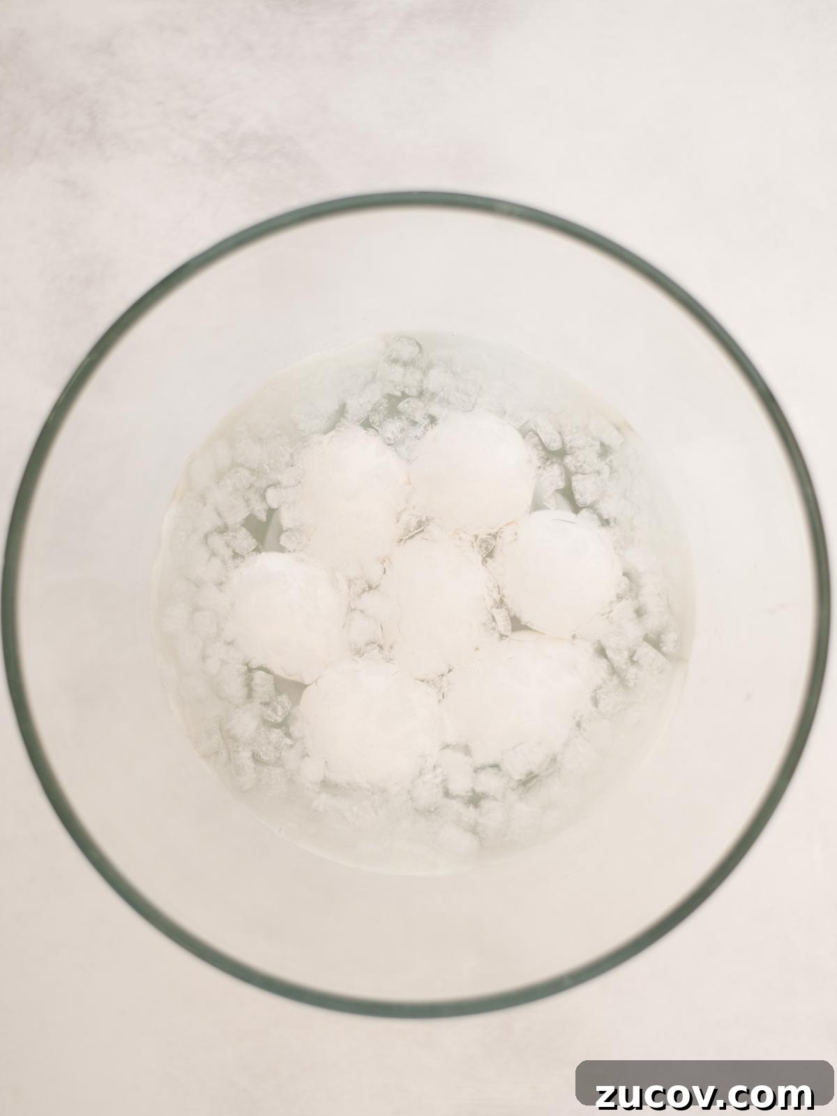 Perfect Hard-Boiled Eggs: Foolproof Method for Firm Whites & Creamy Yolks 4 Hardboiled eggs in their shell, sitting in ice water.