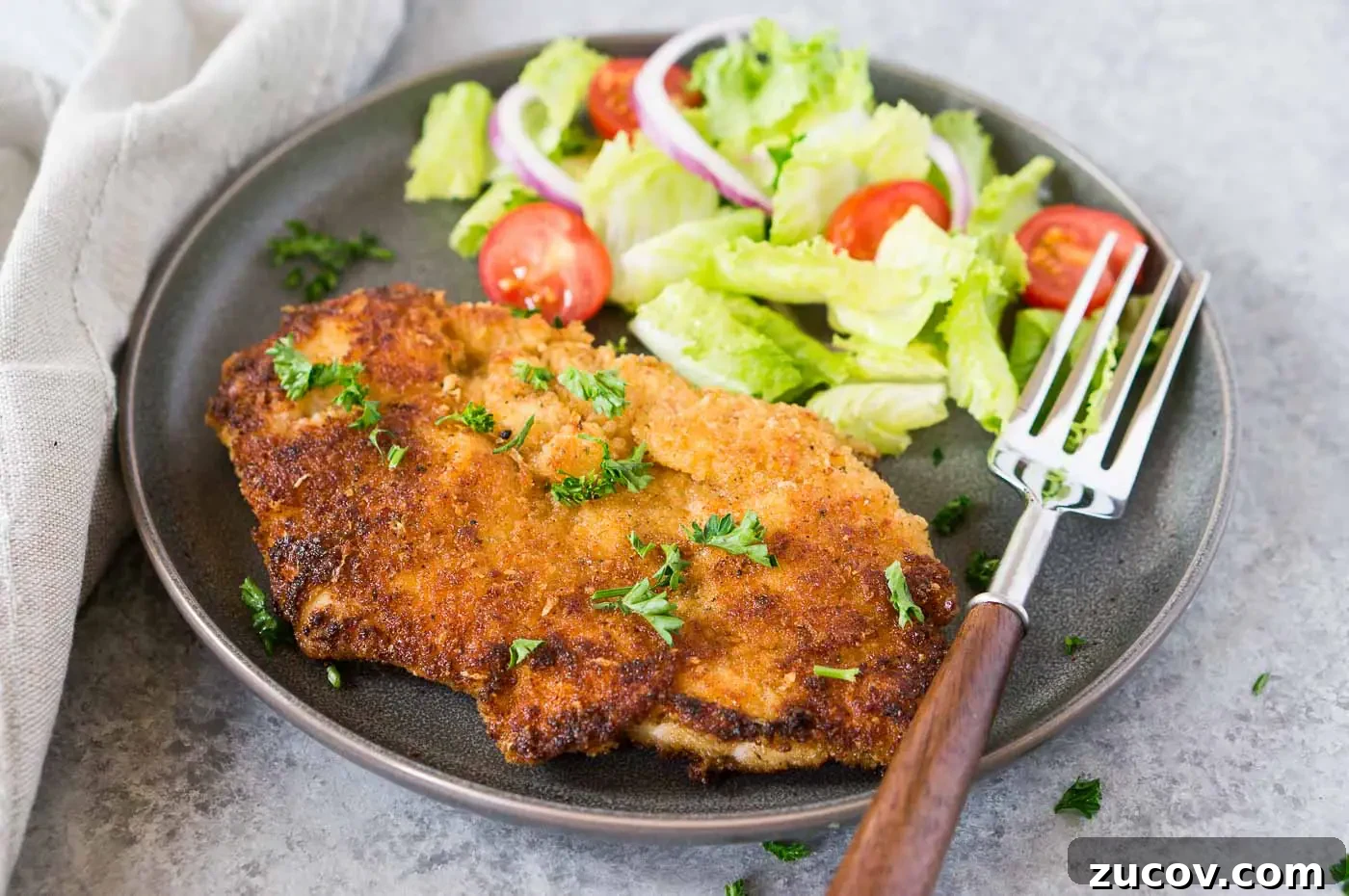 Crispy Chicken Milanese Recipe — Quick Italian-Style Cutlets 3 close up image of chicken milanese on a plate with a salad