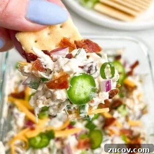 Jalapeño Popper Chicken Salad Recipe — Creamy, Spicy Twist 7 jalapeno popper chicken salad on a cracker being held in hand