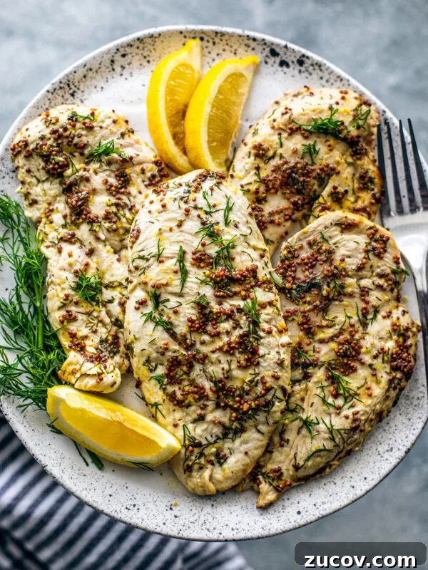 Crispy Juicy Air Fryer Turkey Breast Recipe 10 Plate of chicken breasts with lemon wedges and fresh dill sprigs.