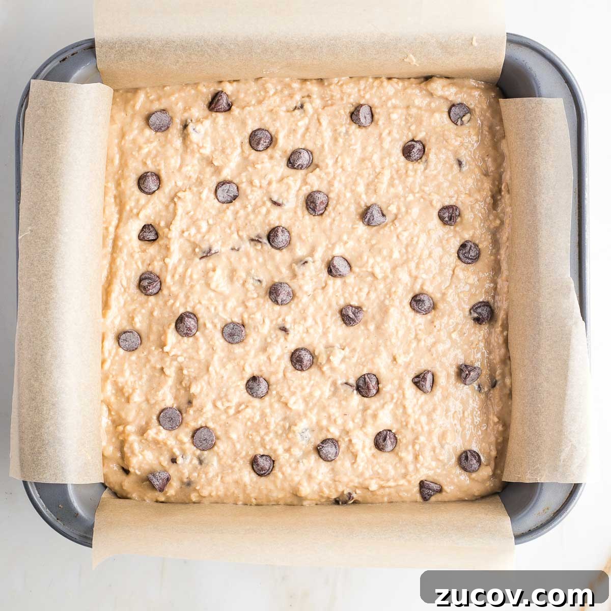 Vegan White Bean Blondies: Chewy, Protein-Packed Treats 11 Square baking pan filled with blondies batter with chocolate chips.