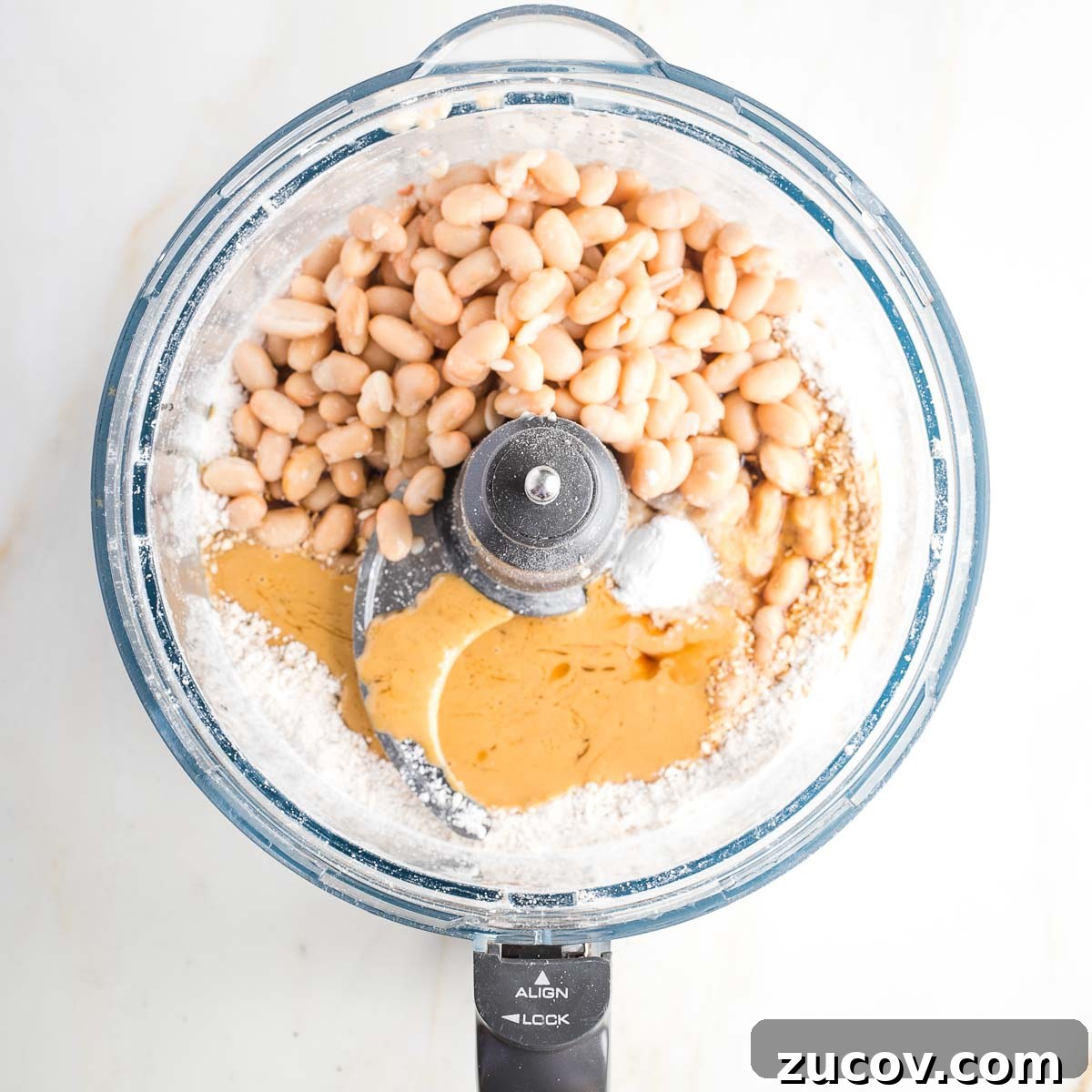 Vegan White Bean Blondies: Chewy, Protein-Packed Treats 7 Food processor bowl withwhite beans, flour, tahini, baking powder and syrup.