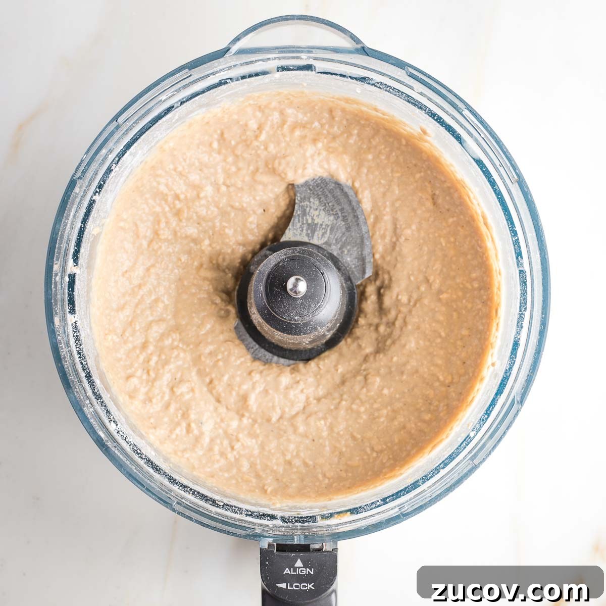 Vegan White Bean Blondies: Chewy, Protein-Packed Treats 8 Light colored cookie batter in the bowl of a food processor.