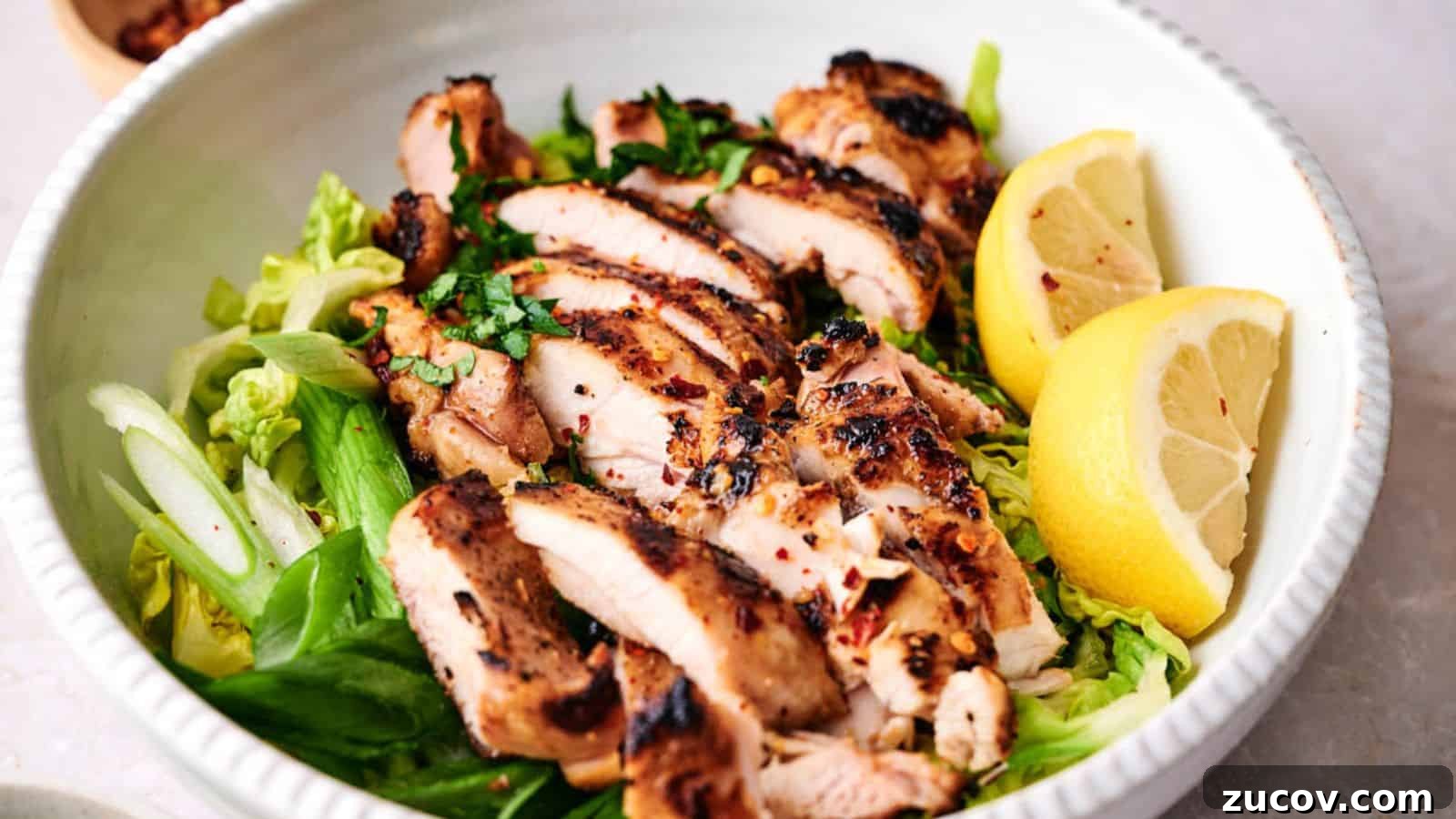 21 Summer Budget Meals That Make Takeout Obsolete 23 Grilled chicken breast slices served over a bed of greens with lemon wedges on the side.