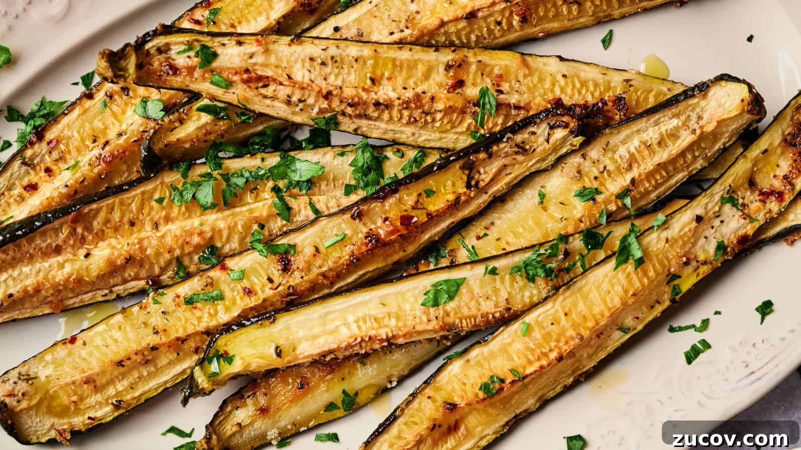 21 Summer Budget Meals That Make Takeout Obsolete 6 Roasted zucchini halves garnished with chopped parsley on a white plate.