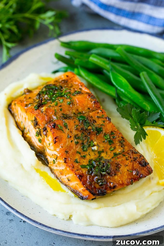 Roasted salmon with mashed potatoes and green beans A roasted salmon fillet over mashed potatoes with green beans.