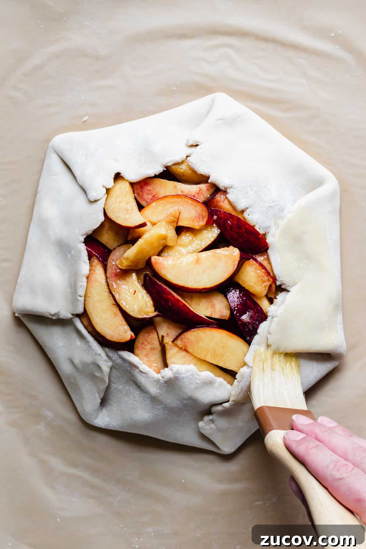 Peach and Almond Frangipane Galette Recipe 10 Egg wash being brushed onto the crust of the galette