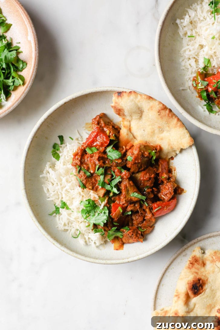 Authentic Chicken Jalfrezi Recipe: Spicy Tangy Curry at Home 14 Chicken Jalfrezi in a white bowl with rice and naan on the side