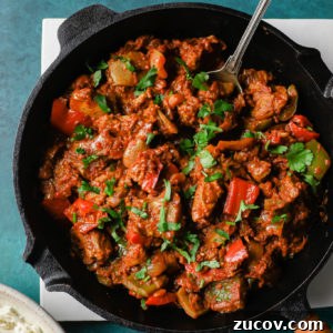 Authentic Chicken Jalfrezi Recipe: Spicy Tangy Curry at Home 15 Chicken Jalfrezi in a black skillet with a silver spoon