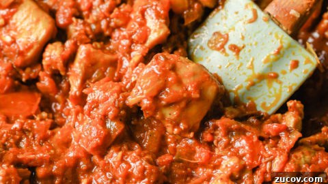 Authentic Chicken Jalfrezi Recipe: Spicy Tangy Curry at Home 18 Tomatoes added to chicken thighs in a black skillet