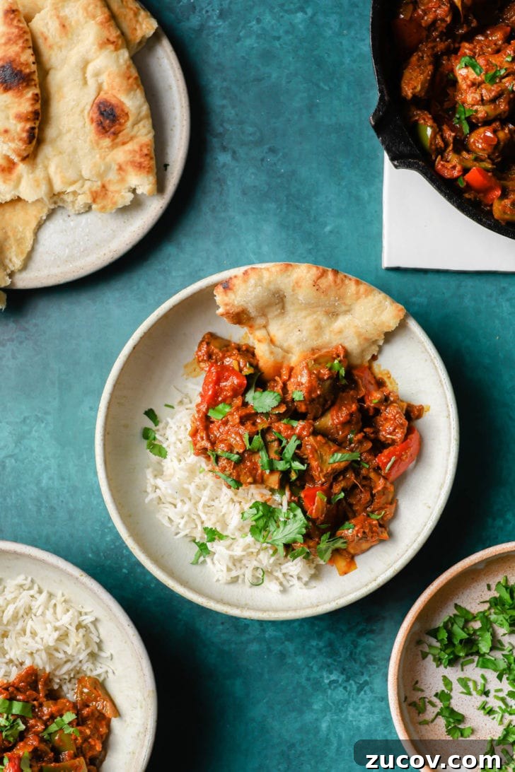Authentic Chicken Jalfrezi Recipe: Spicy Tangy Curry at Home 4 Chicken Jalfrezi in a white bowl with rice and naan on the side