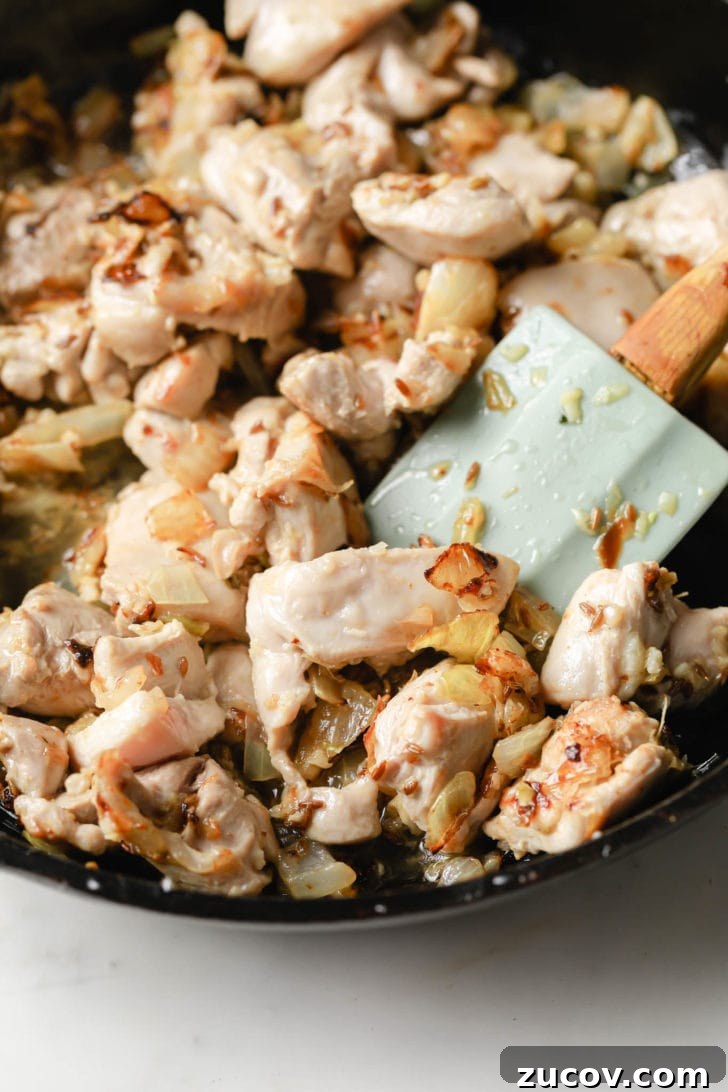 Authentic Chicken Jalfrezi Recipe: Spicy Tangy Curry at Home 7 Chicken thighs sauteed in onions in a black skillet