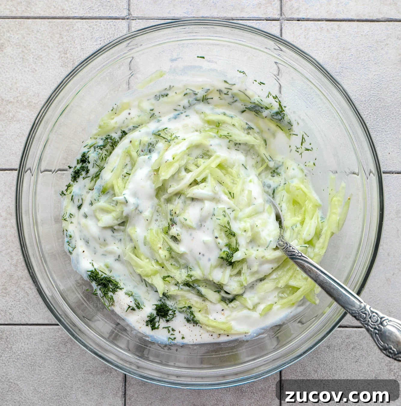 Vegan Kofta Recipe: Flavorful Plant-Based Meatballs 4 stirring the ingredients for tzatziki sauce in a glass bowl.
