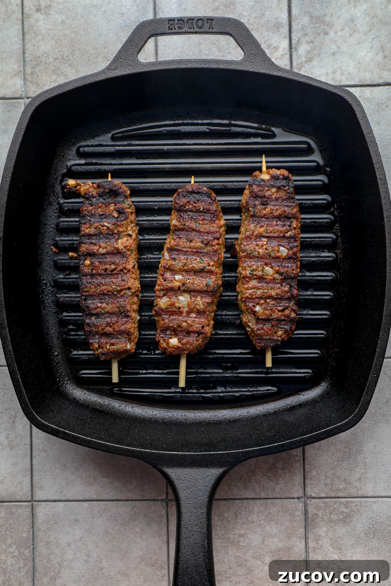 Vegan Kofta Recipe: Flavorful Plant-Based Meatballs 8 grilling 3 vegan kofta kebabs on a black grill pan.