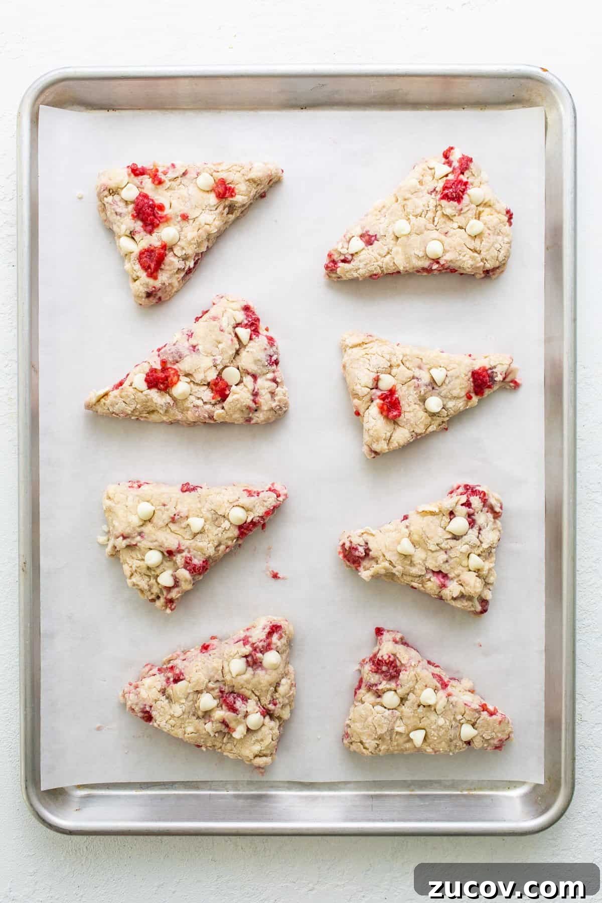 White Chocolate and Raspberry Scones Recipe for Brunch 4 Cranberry almond scones on a baking sheet.