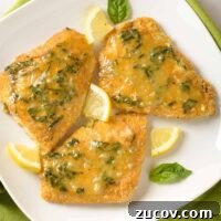 Lemon Basil Butter Oven-Fried Fish Recipe 4 Three pieces of breaded, oven-fried fish fillets topped with lemon butter infused with fresh basil and garnished with basil leaves and lemon wedges.