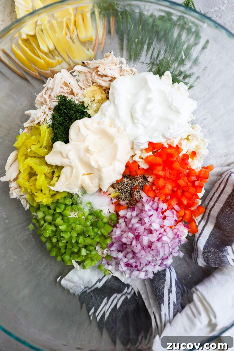 Greek-Style Feta Chicken Salad with Lemon-Dill Dressing 4 A large mixing bowl filled with shredded chicken, mayonnaise, Greek yogurt, bell pepper, red onion, celery, pepperoncini, fresh dill and garlic