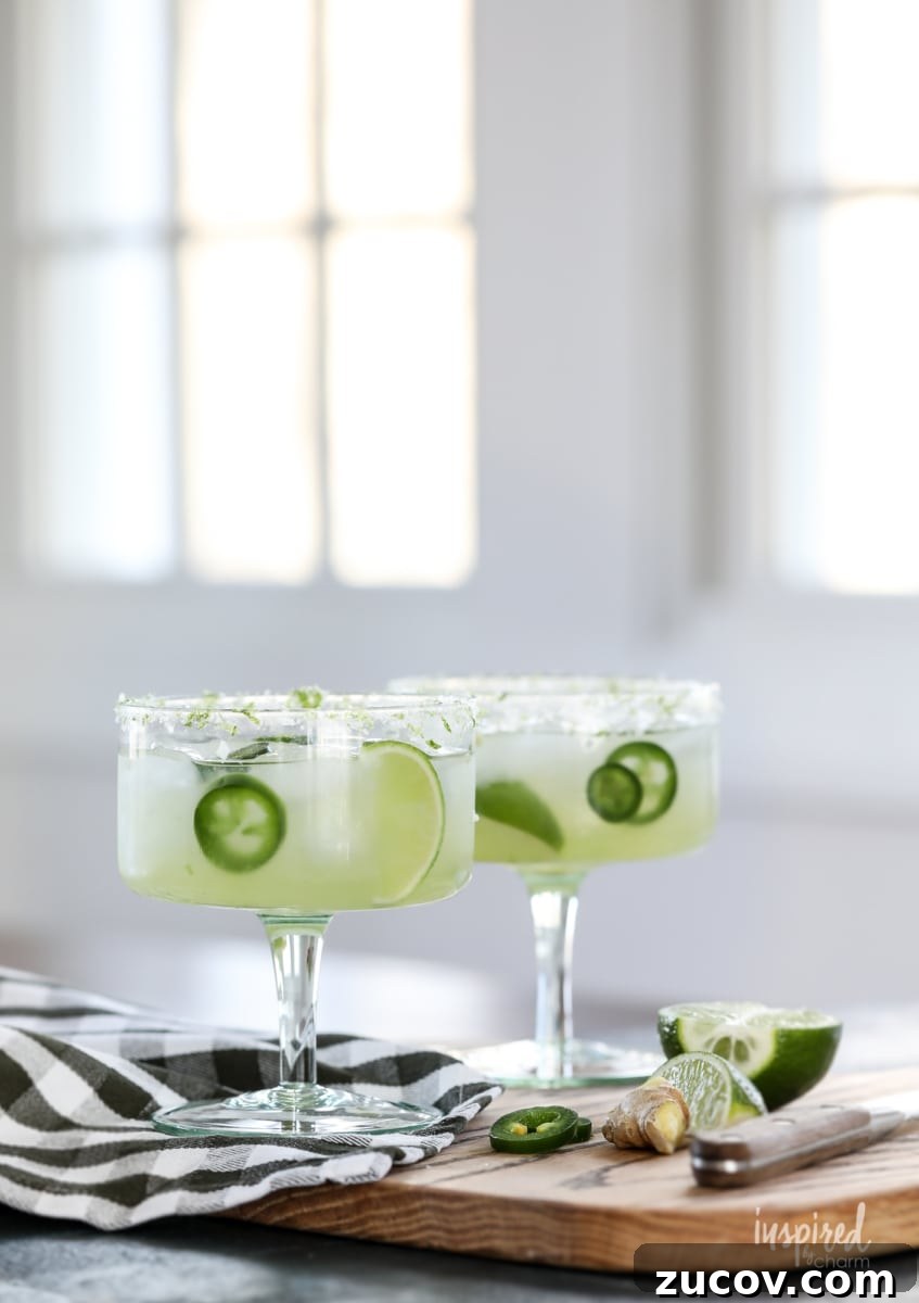 Spicy Jalapeño Margarita Recipe: How to Make It at Home 3 two jalapeño margaritas in glasses on a cutting board.
