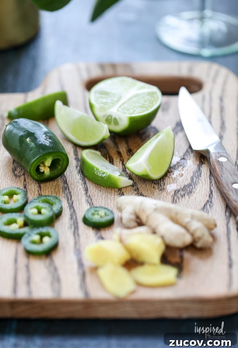 Spicy Jalapeño Margarita Recipe: How to Make It at Home 5 sliced limes, jalapeños, and ginger root on a cutting board.