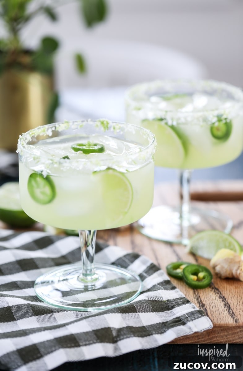 Spicy Jalapeño Margarita Recipe: How to Make It at Home 7 two jalapeño margaritas in glasses on a cutting board.