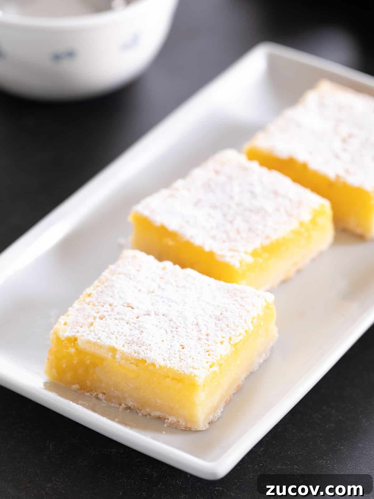 Gluten-Free Lemon Bar Recipe: Zesty, Tart Citrus Squares 2 Three lemon bars on a white platter