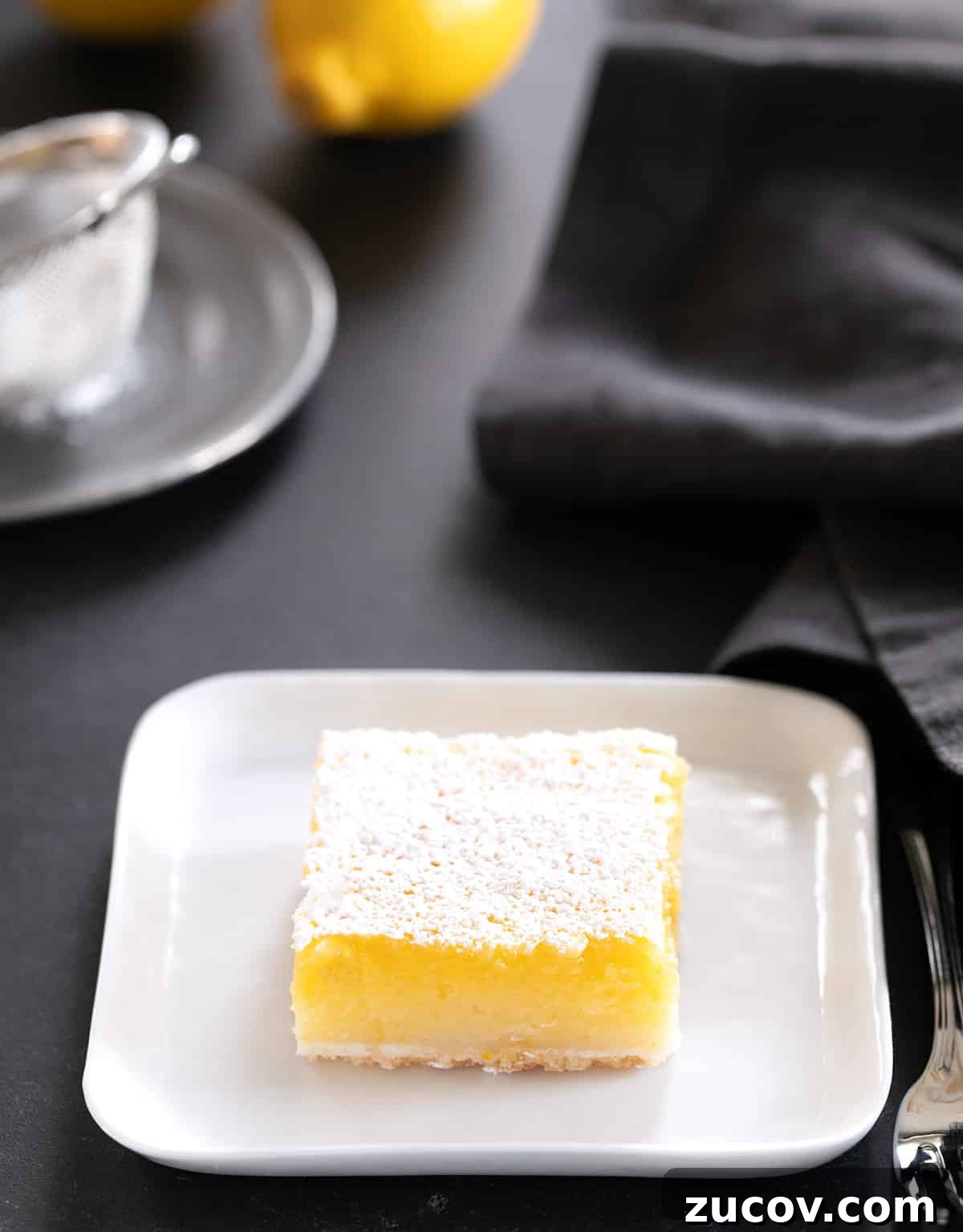 Gluten-Free Lemon Bar Recipe: Zesty, Tart Citrus Squares 19 A single lemon bar on a small square plate