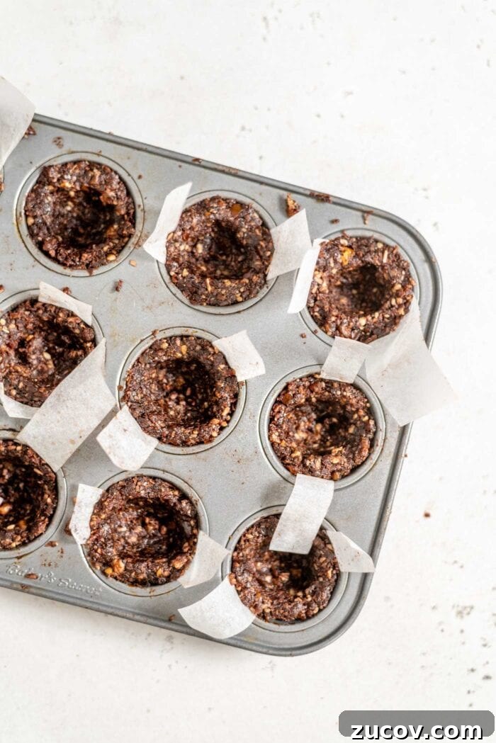 No-Bake Chocolate Caramel Tart Recipe for Quick Desserts 7 Unfilled chocolate tarts in a mini muffin tin.