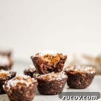 A stack of 2 chocolate caramel tarts on a small plate.