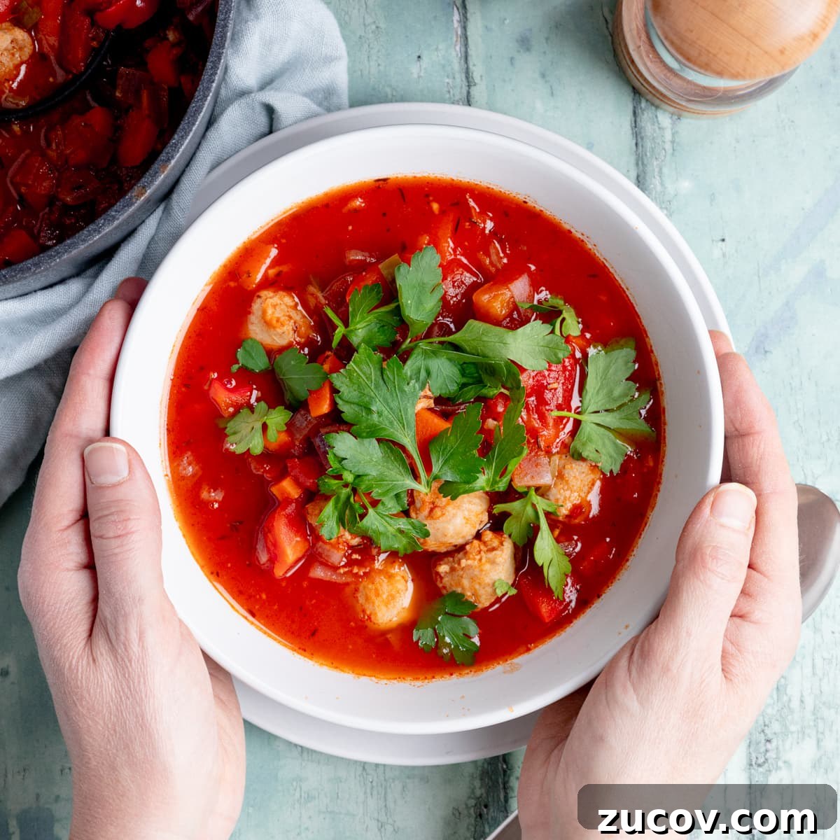 Tomato Sausage Soup for Quick Midweek Dinners 2 Bowl of tomato and sausage soup with hands
