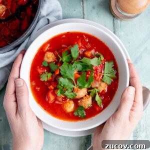 Tomato Sausage Soup for Quick Midweek Dinners 5 Bowl of tomato and sausage soup with hands