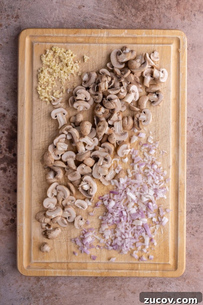 20-Minute Mushroom Marsala Pasta Recipe (Vegetarian) 4 Prepped garlic, mushrooms, and shallots on a cutting board