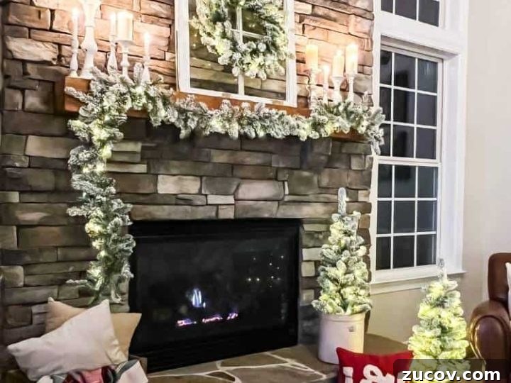 Stone fireplace with wood mantel decorated for Christmas with flocked set and white candles at night