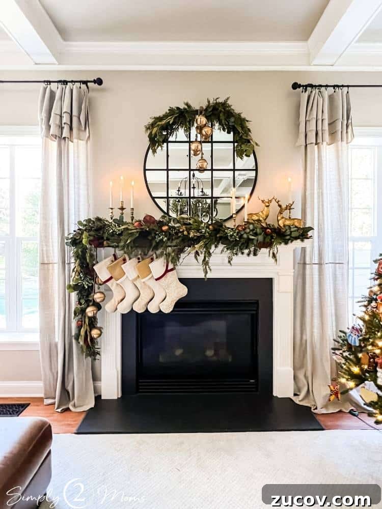 13 Elegant Christmas Fireplace Decorating Ideas to Try This Year 4 Gas fireplace with asymmetrical Christmas garland, stockings, and round mirror with greenery half wreath.