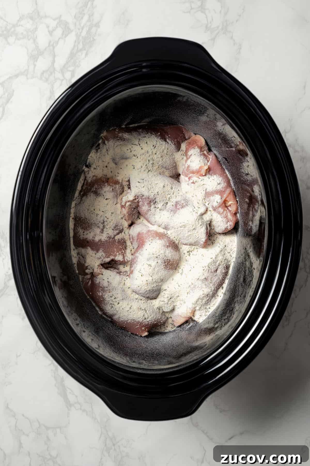 Mississippi Chicken Recipe: Slow Cooker & Oven Methods 5 Chicken thighs topped with ranch mix and onion soup mix inside the slow cooker.