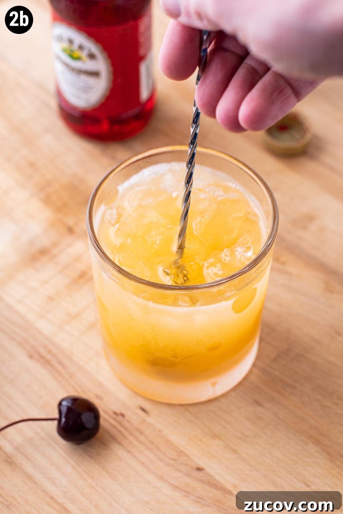Tequila Sunrise Cocktail Recipe: Ingredients, Tips & Variations 7 Stirring tequila and orange juice together in a cocktail glass with a bar spoon.