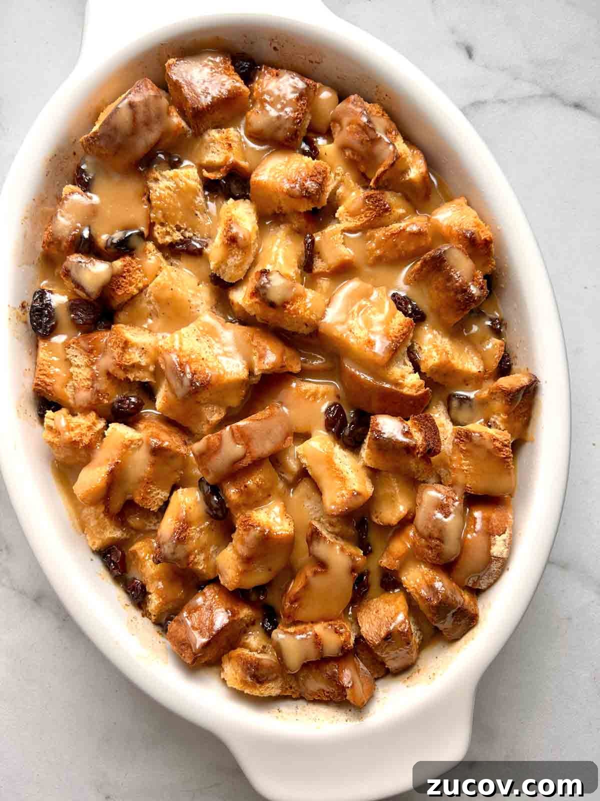 Classic Bread Pudding Recipe with Caramel Sauce and Vanilla 2 bread pudding with vanilla sauce drizzled over it.