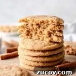 brown butter snickerdoodle cookies stacked on serving board with top cookies split in half