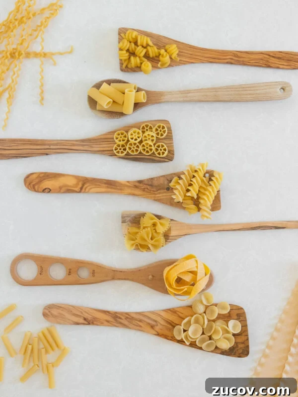 different pasta shapes with wooden spoons