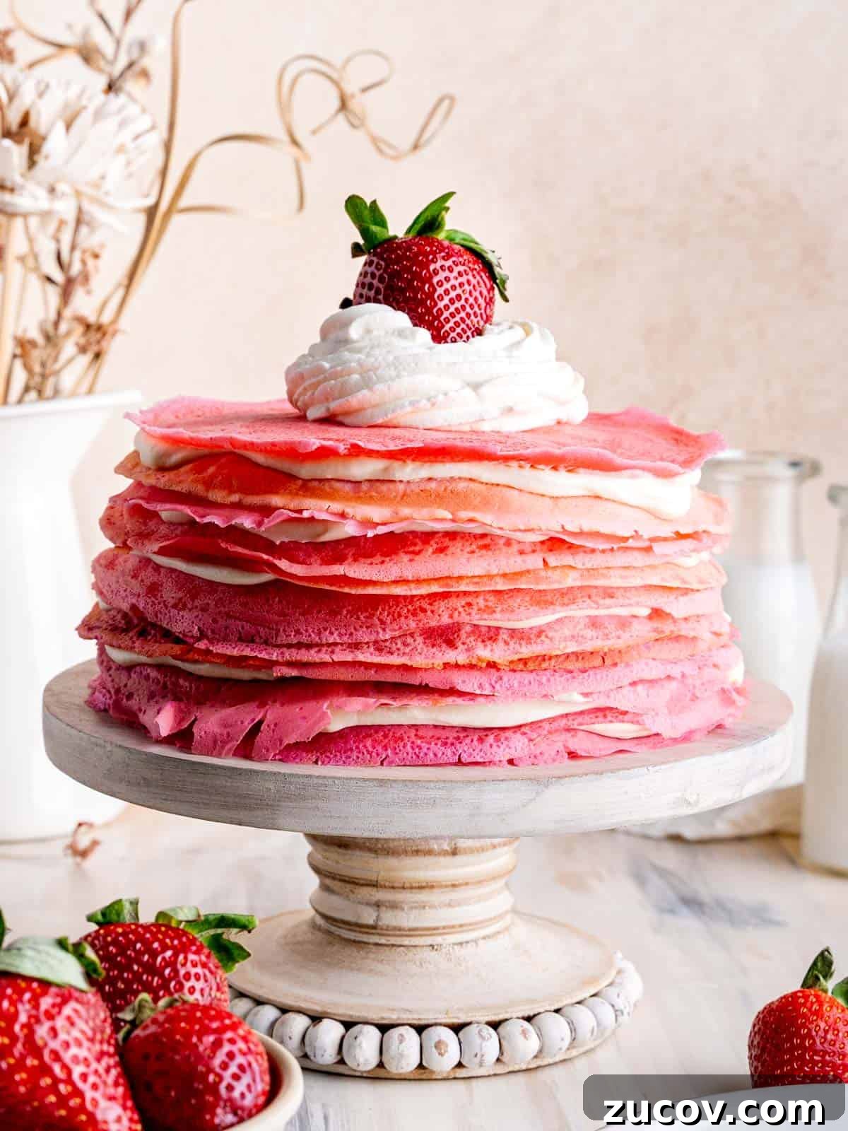 Strawberry & Cream Layered Crepe Cake Recipe 2 A strawberries and cream crepe cake topped with whipped cream and a strawberry.
