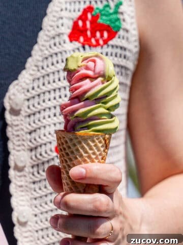 Kayla Burton holding strawberry matcha ice cream in a sugar cone.