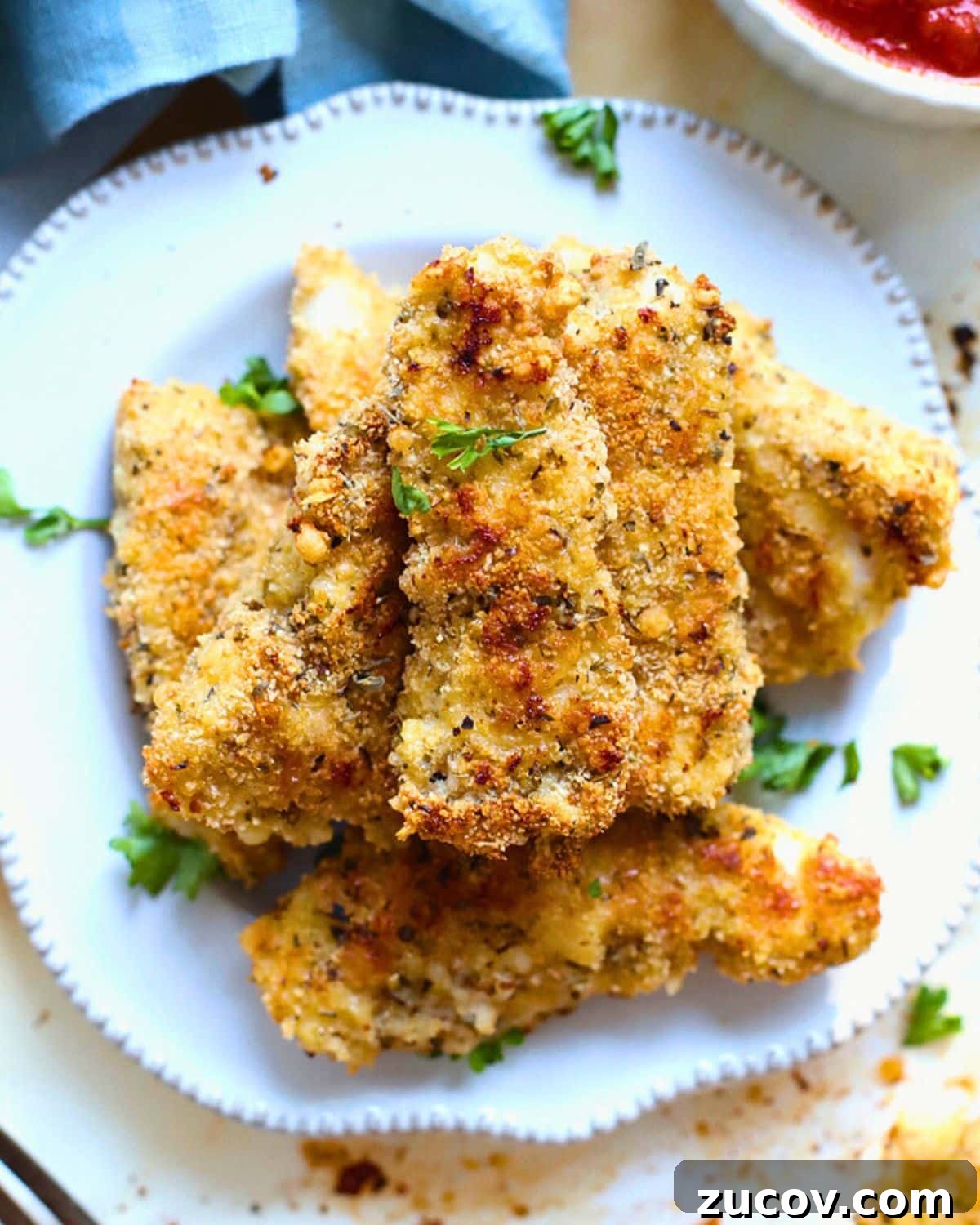 How to Reheat Chicken Tenders: 4 Quick Methods for Crispy Results 3 Cooked chicken tenders stacked on a plate.
