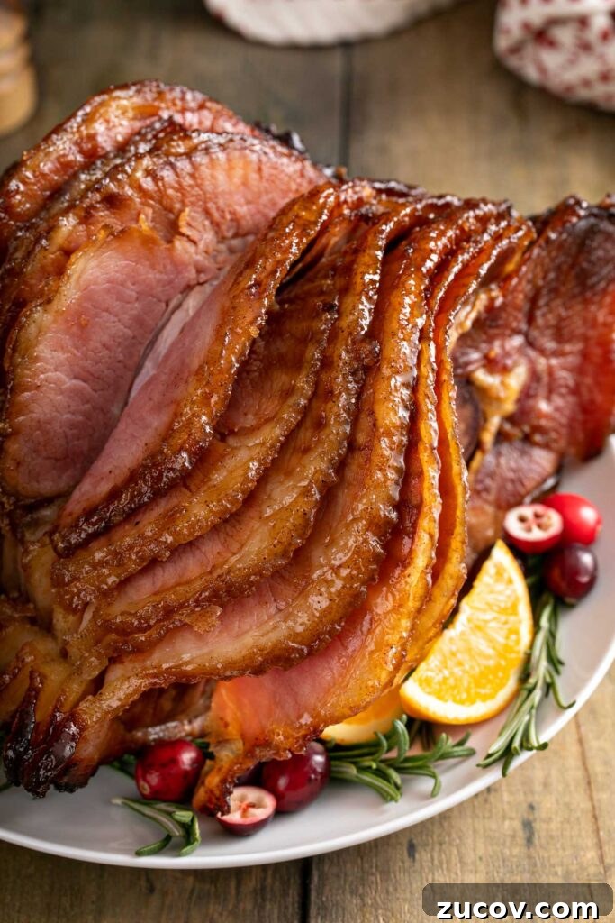 Homemade Honey Baked Ham Recipe (Copycat) 3 Caramelized slices of a spiral baked ham on a white platter.
