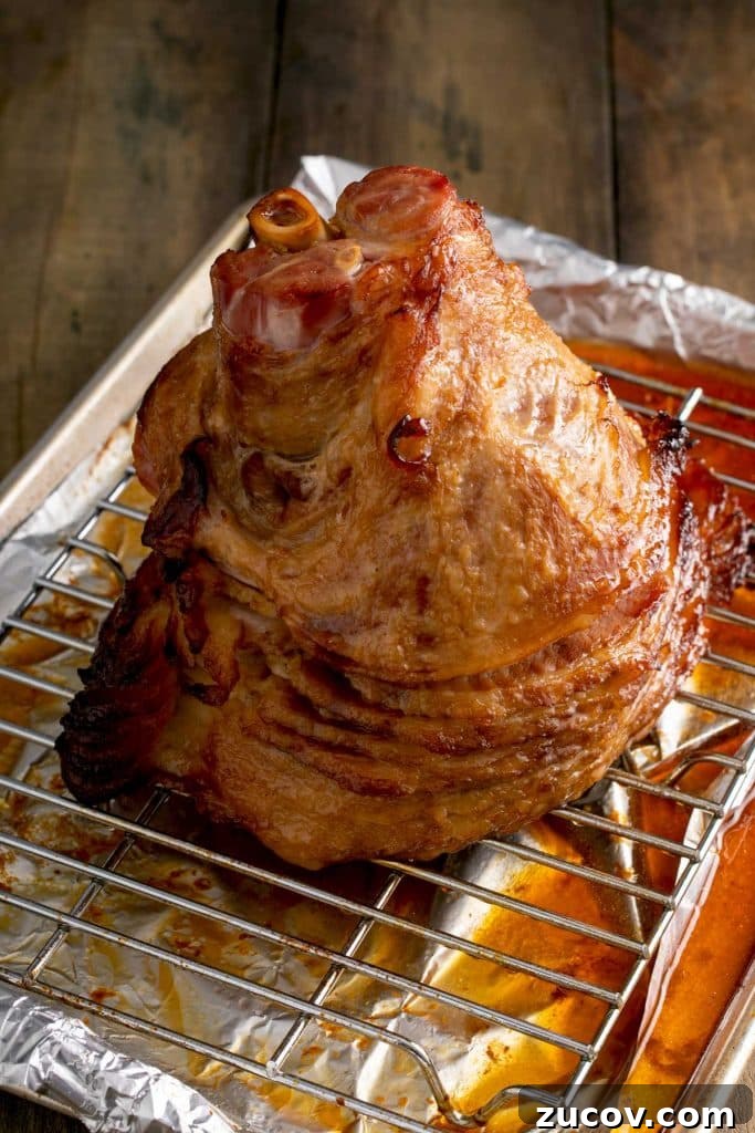 Homemade Honey Baked Ham Recipe (Copycat) 8 caramelized baked spiral ham on a baking sheet with a wire rack insert