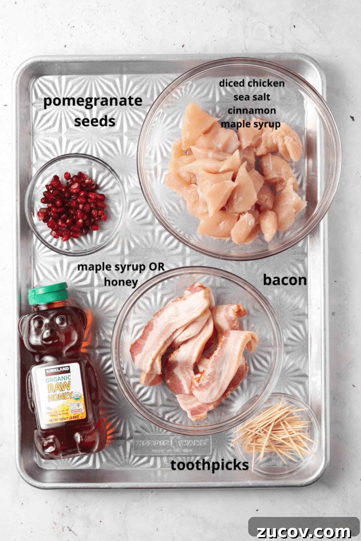 Crispy Bacon-Wrapped Chicken Bites with Maple Glaze 3 Bacon wrapped chicken bite ingredients in glass containers on a metal tray.