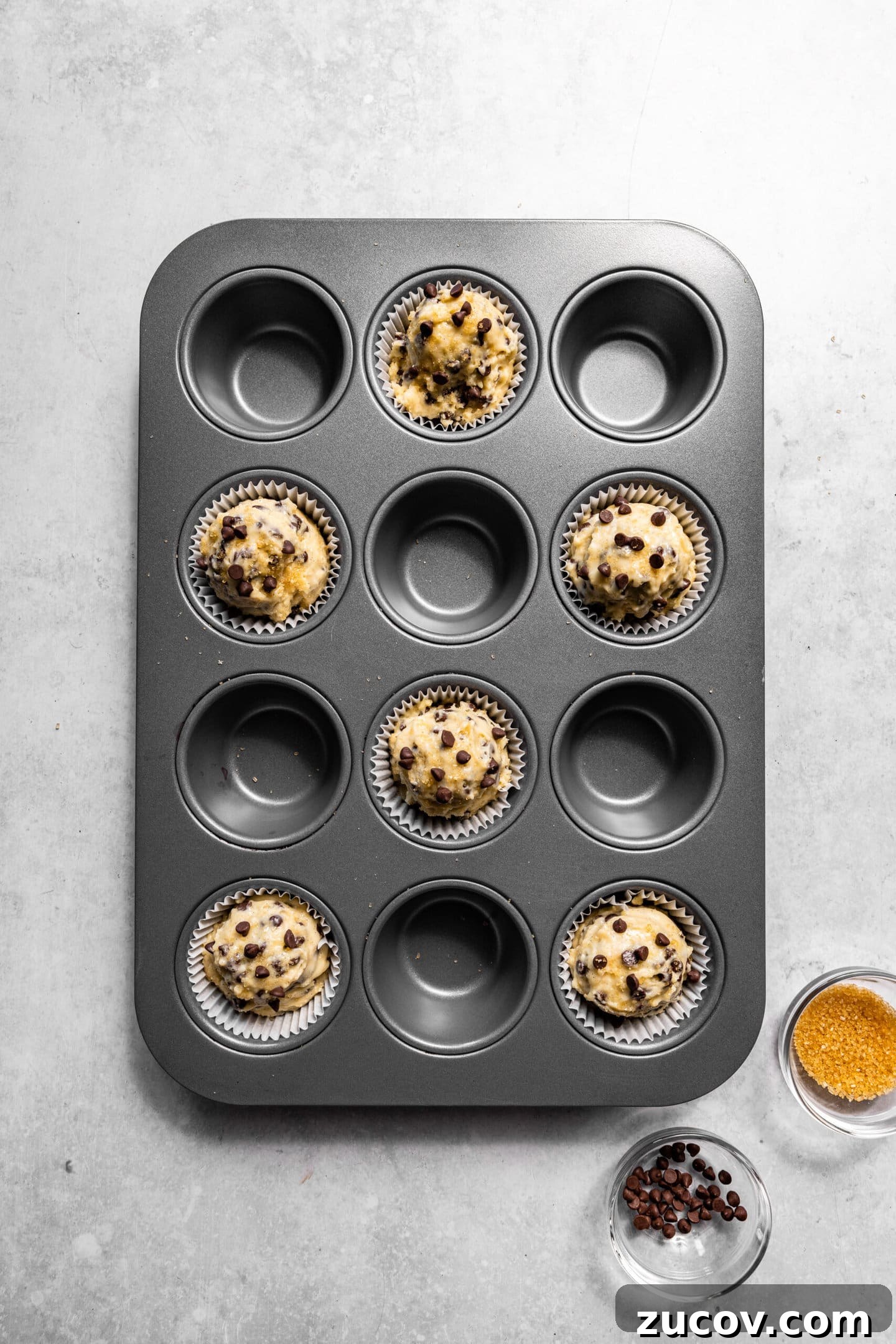Small-Batch Chocolate Chip Muffins Made with Sour Cream 9 Muffin batter scooped into muffin pan with raw sugar sprinkled on top